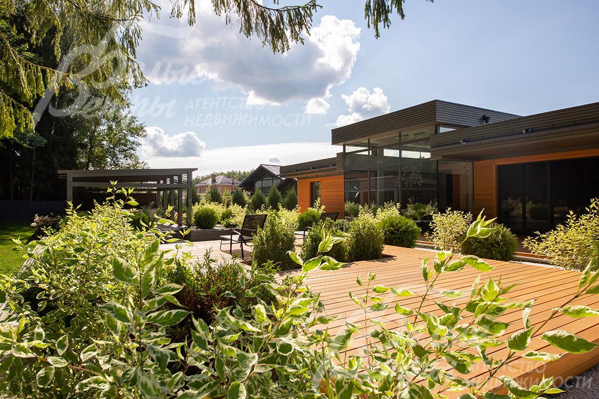 Стильная открытая терраса между домом и лесными деревьями