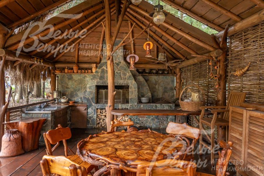 В беседке-барбекю - каменный мангал, печь под казан, кухня с подогревом воды, садовая мебель