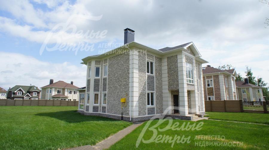 На участке газон, дорожка вымощена брусчаткой