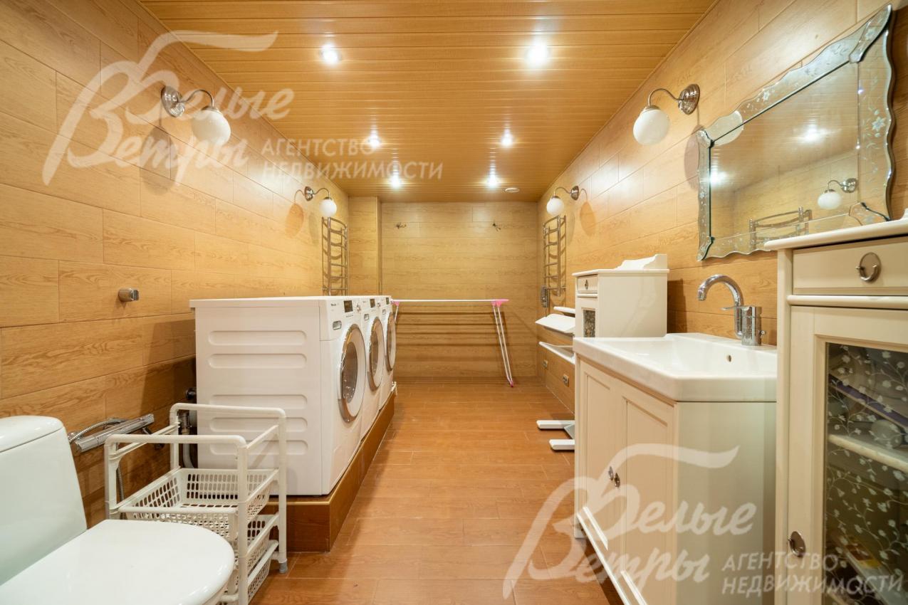 Постирочная оборудована стиральной и сушильной машинами Miele, необходимой сантехникой