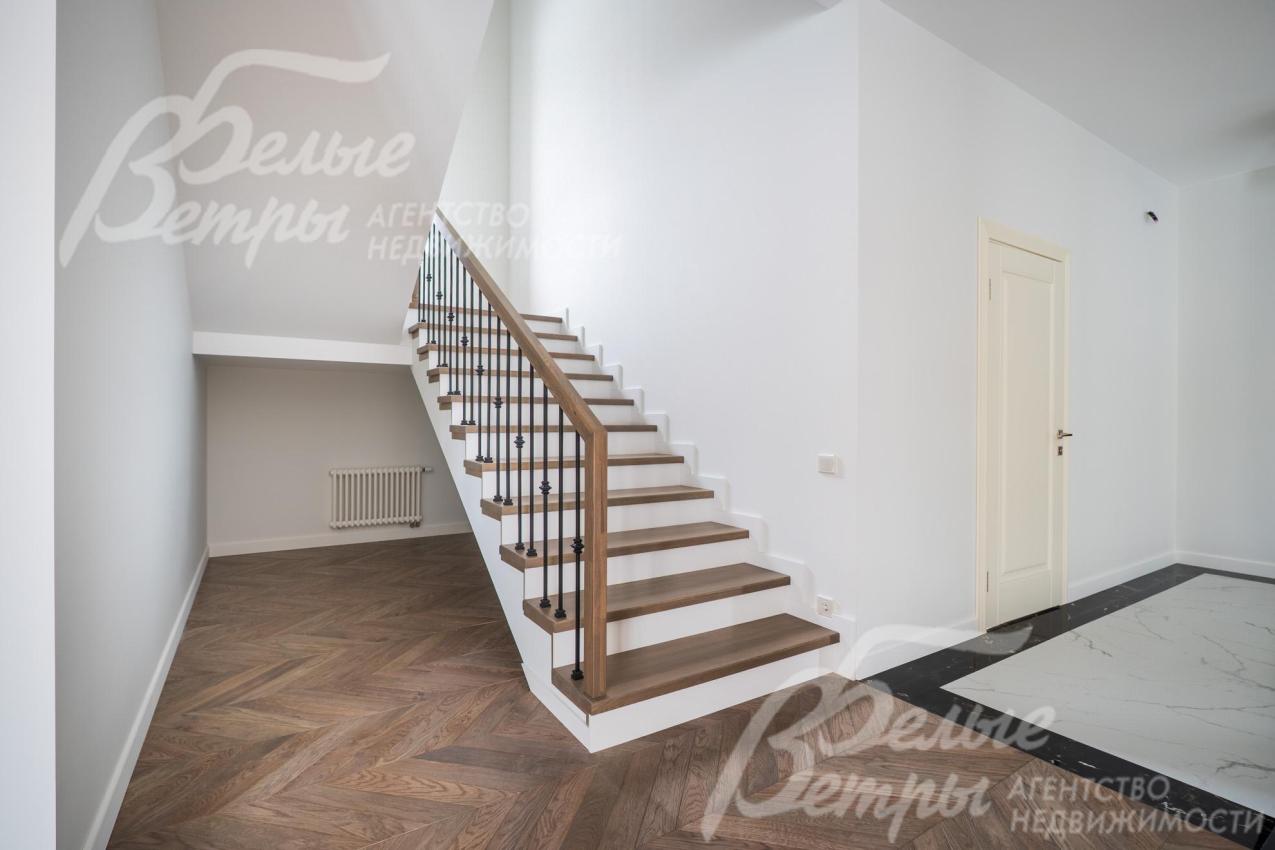 Удобная лестница на монолитном каркасе со ступенями из дуба.