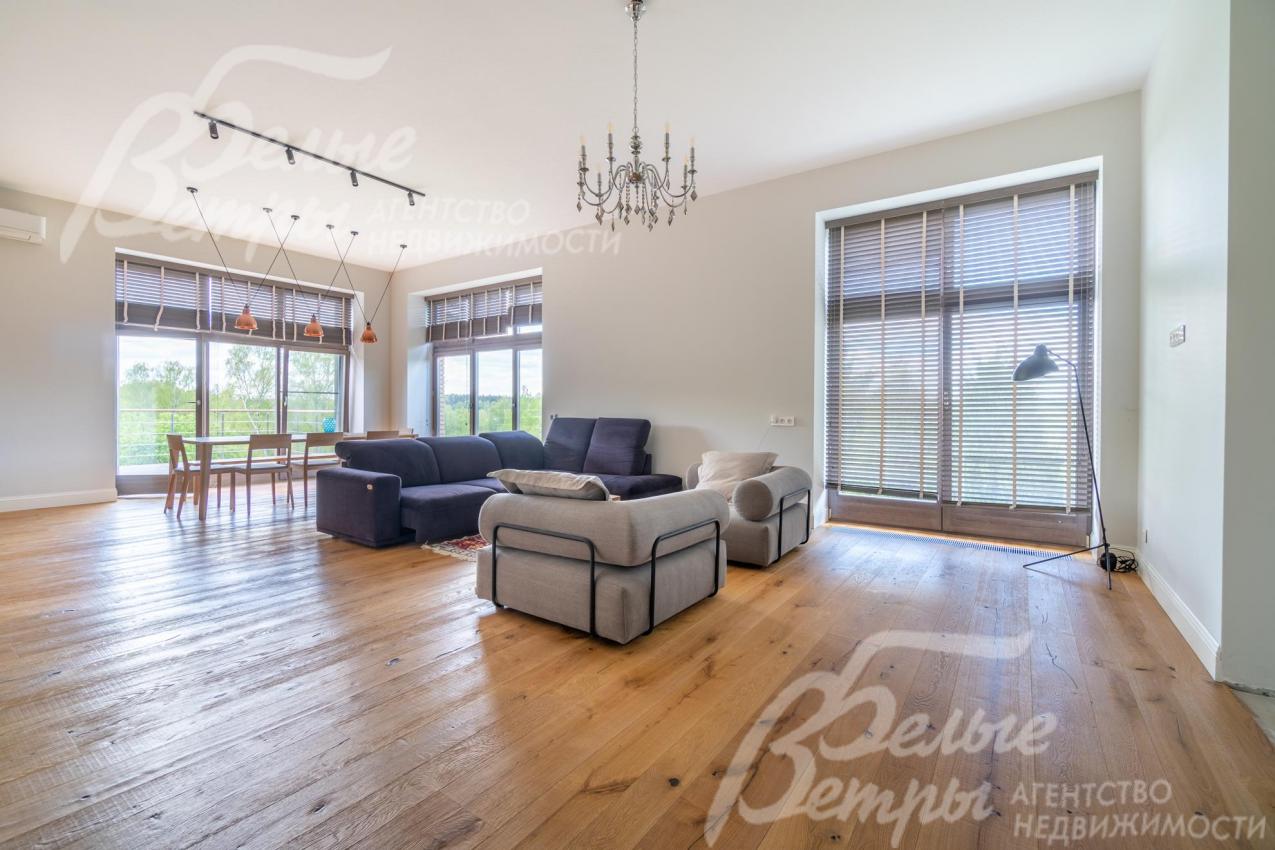 В гостиной-столовой - большие деревянные окна в пол: помещение наполнено естественным светом