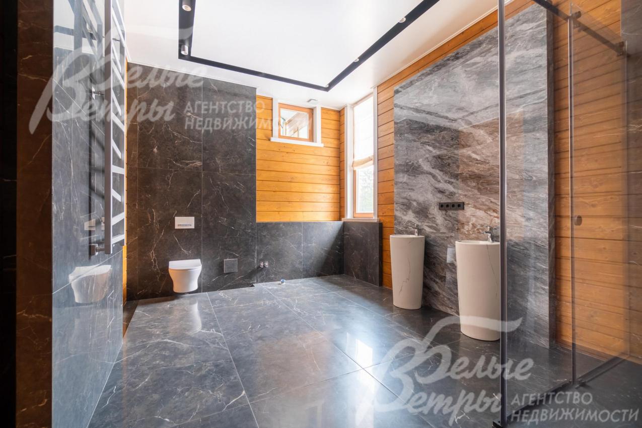 В санузлах - просторные душевые кабины. Этот санузел на втором этаже отделан тёмным керамогранитом с мраморным эффектом, создающем ощущение роскоши и строгости