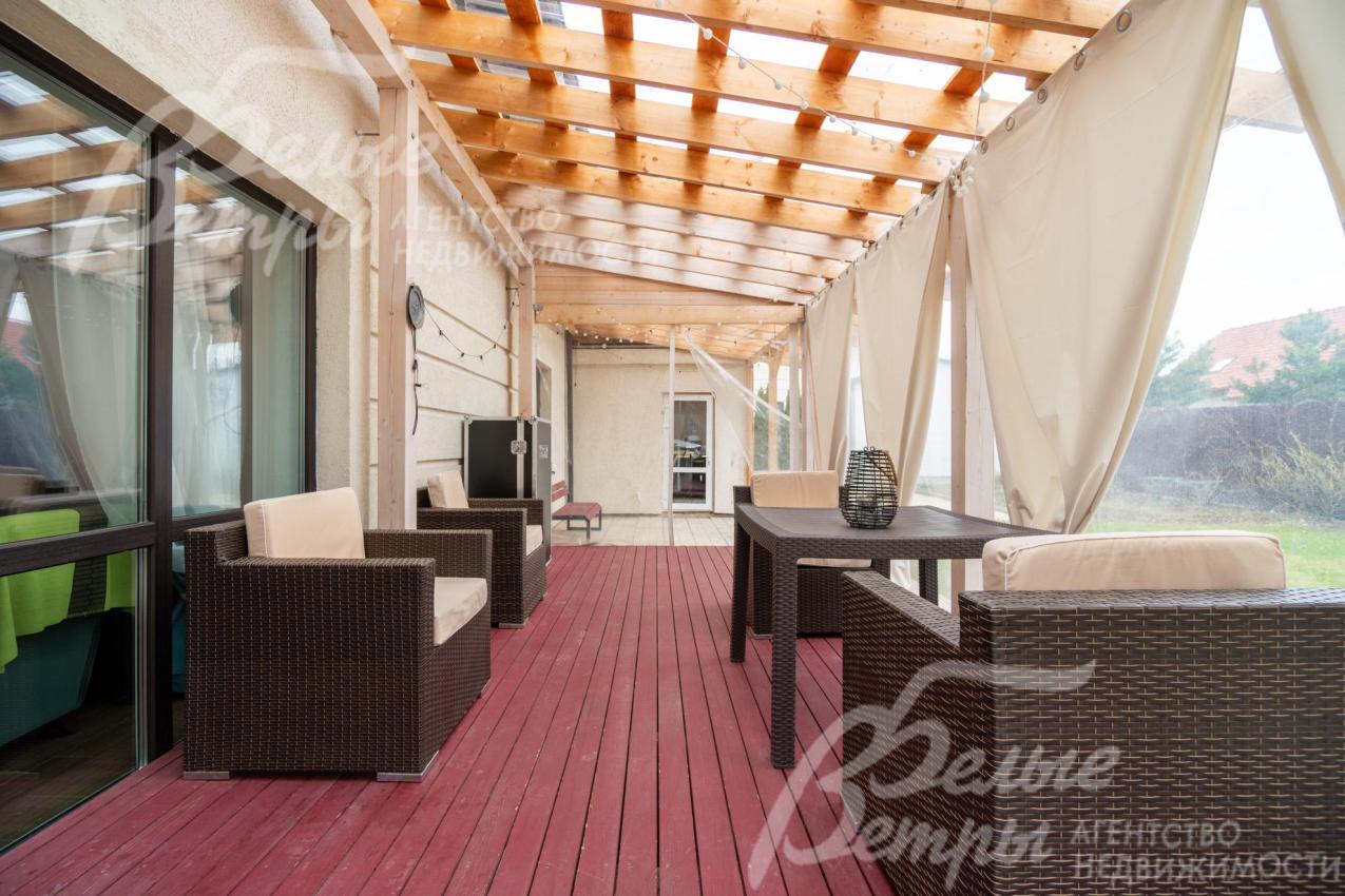 Террасу украшают лёгкие светлые шторы, развешанные вдоль одной из сторон