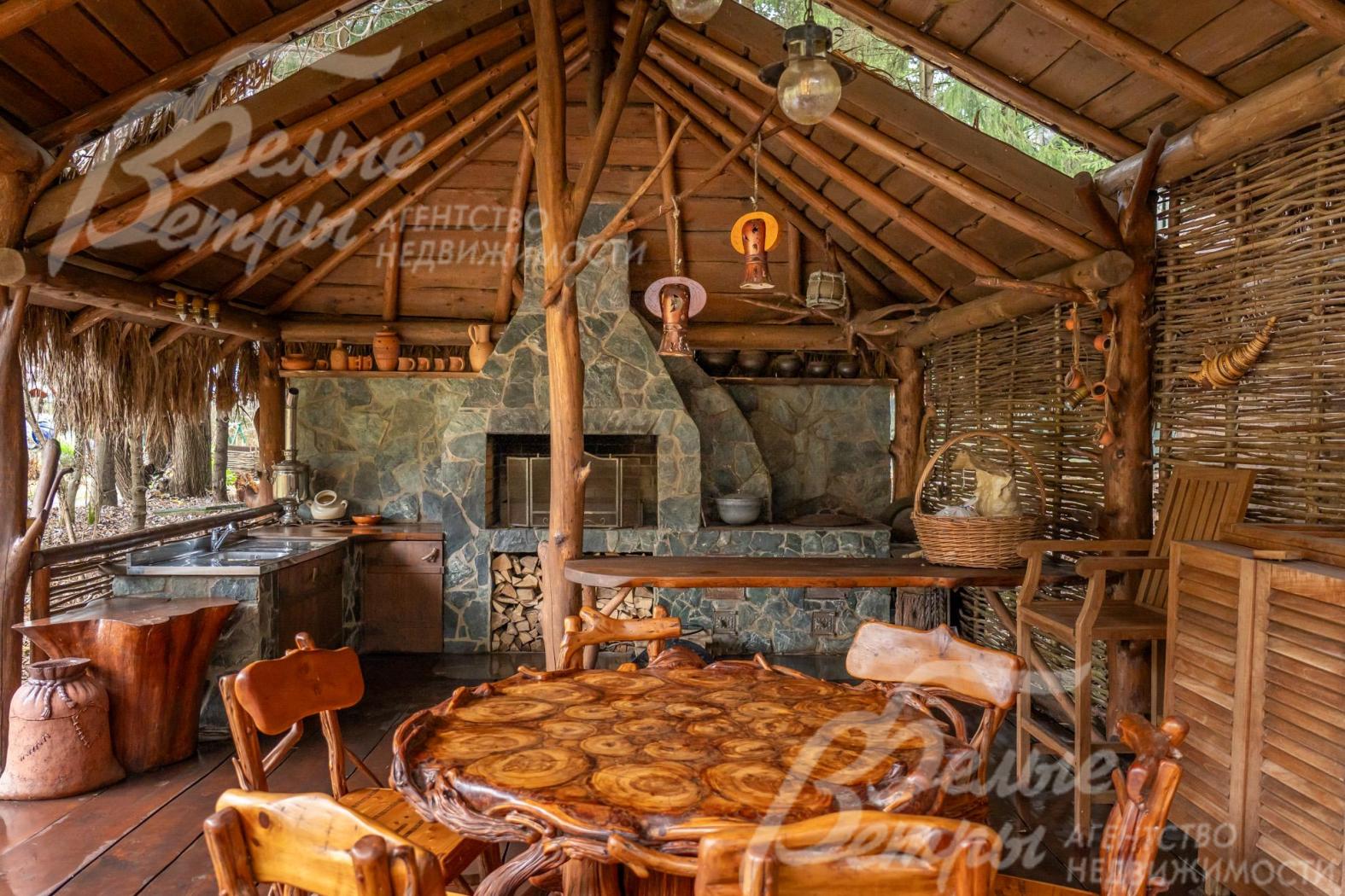 В беседке-барбекю - каменный мангал, печь под казан, кухня с подогревом воды, садовая мебель