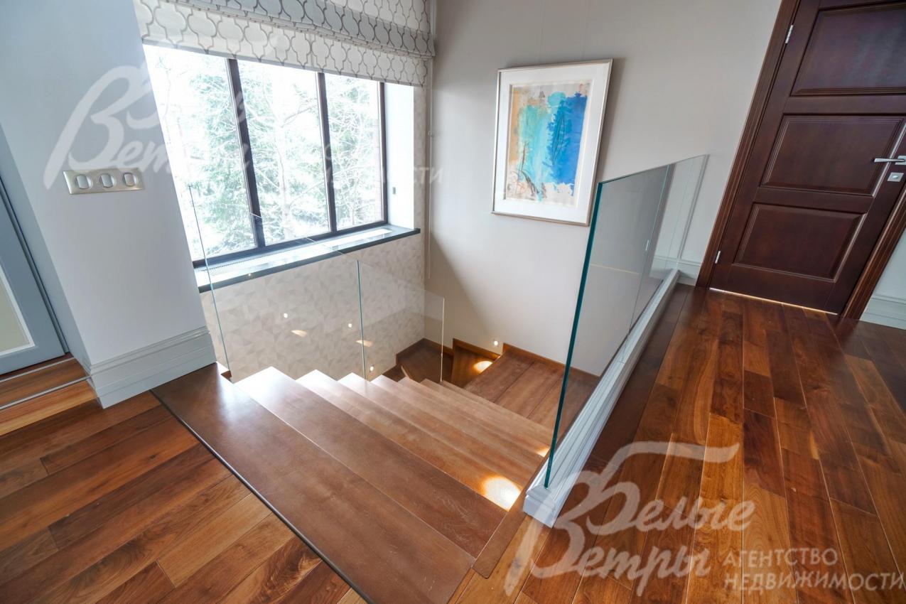 Монолитная лестница со ступенями из бука и стеклянным ограждением. Ширина этого пролета 150см.