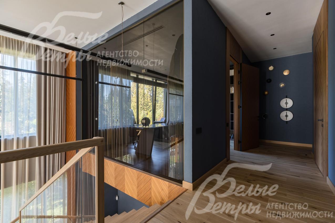 Холл второго этажа. За стеклянной стеной - уютный кабинет с видом на гостиную