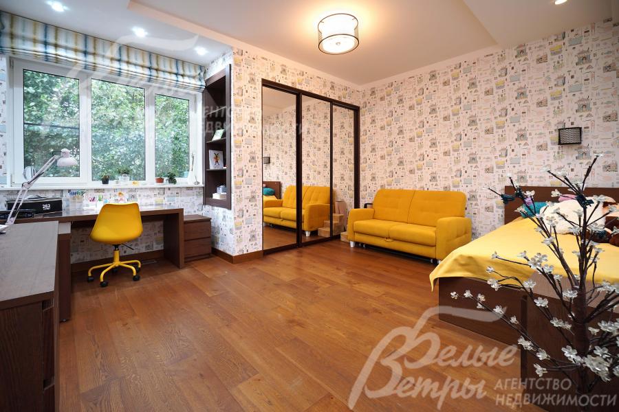 Одна из спален на первом этаже с рабочей зоной у большого окна и встроенным шкафом