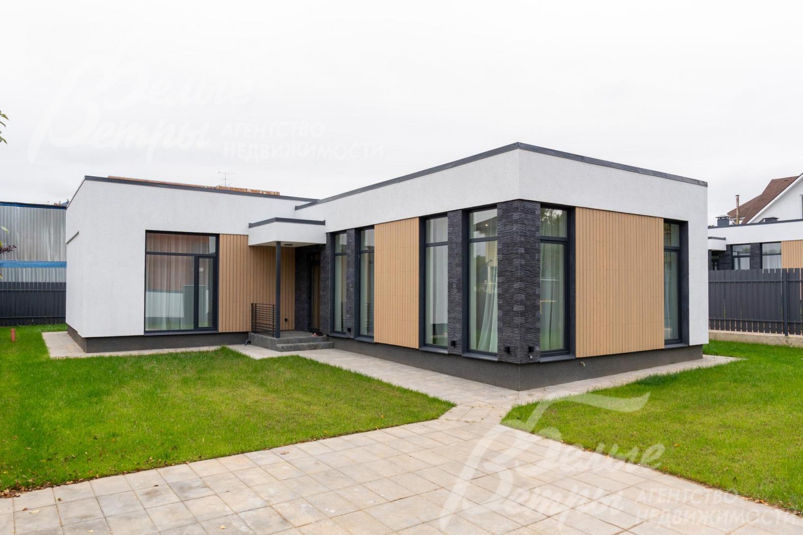 На участке - ровный газон и мощёные дорожки