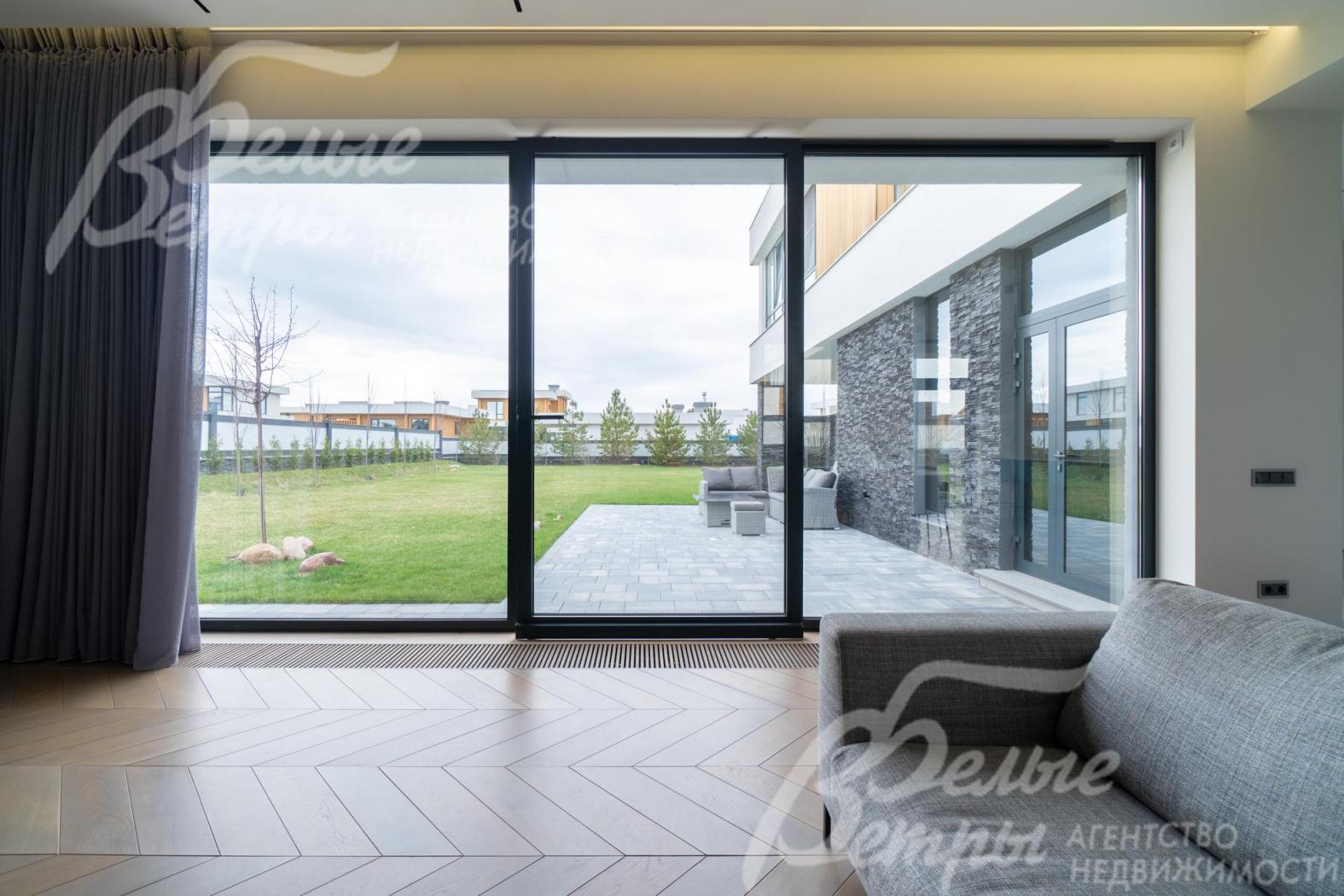 Параллельно-сдвижная система панорамного остекления с выходом на участок из гостиной