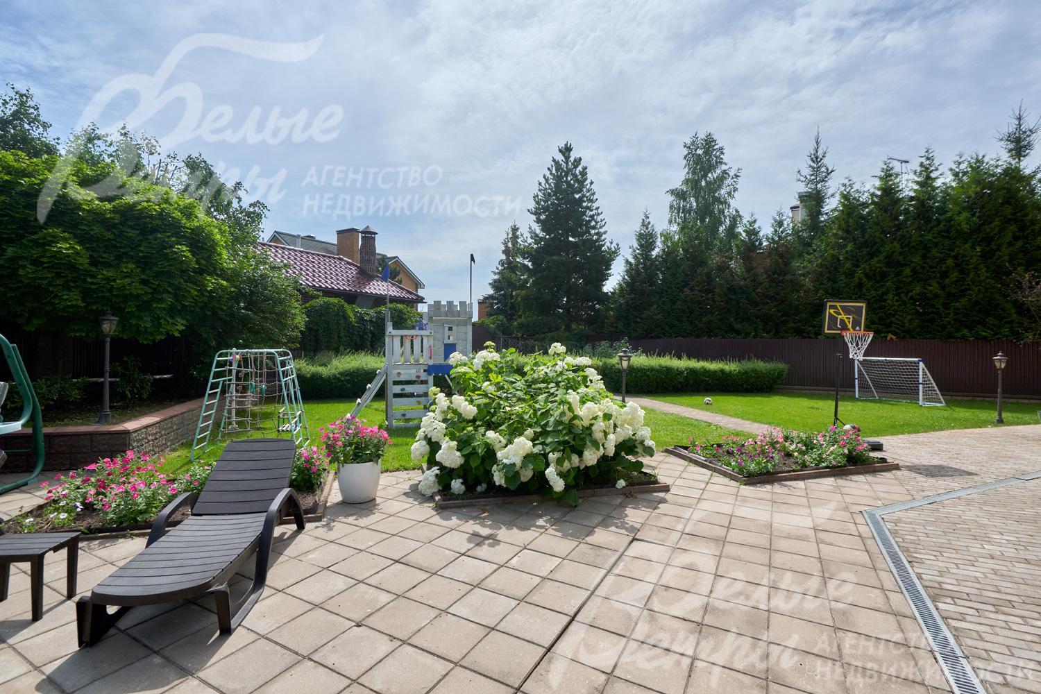 Дорожки и зоны отдыха вымощены плиткой, есть цветочные клумбы и шезлонги