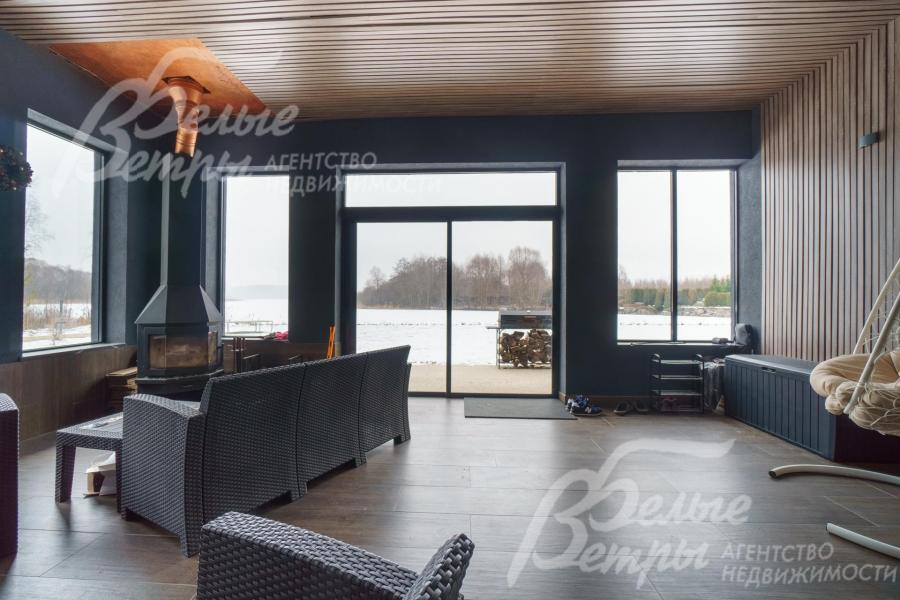 С террасы выход через раздвижное остекление на участок к воде. Камин и подогрев пола позволяют использовать в любое время года.