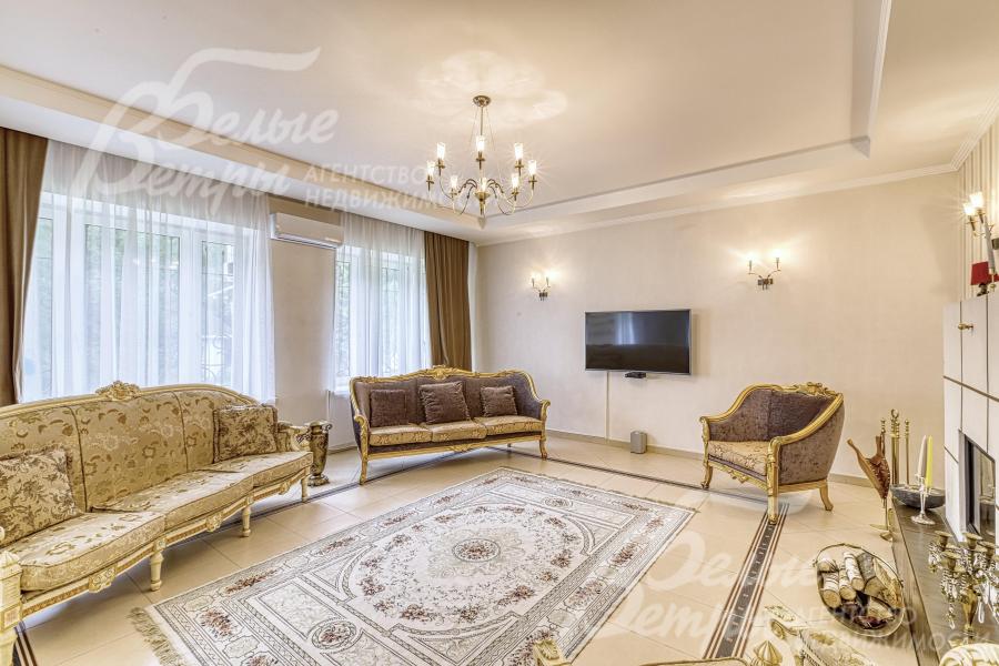 В гостиной - большие окна с видом на участок, установлен телевизор