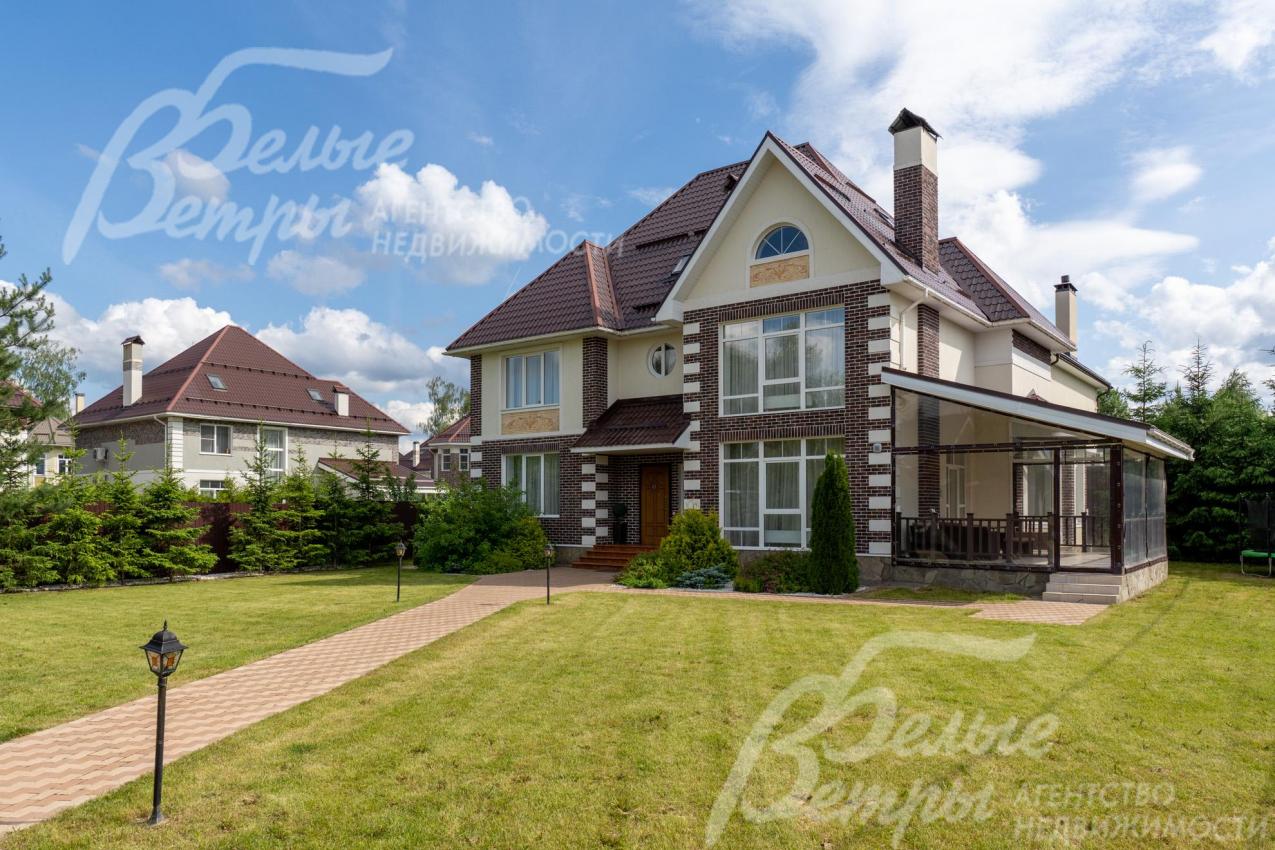 На участке высажен газон, дорожки уложены плиткой, установлены фонари