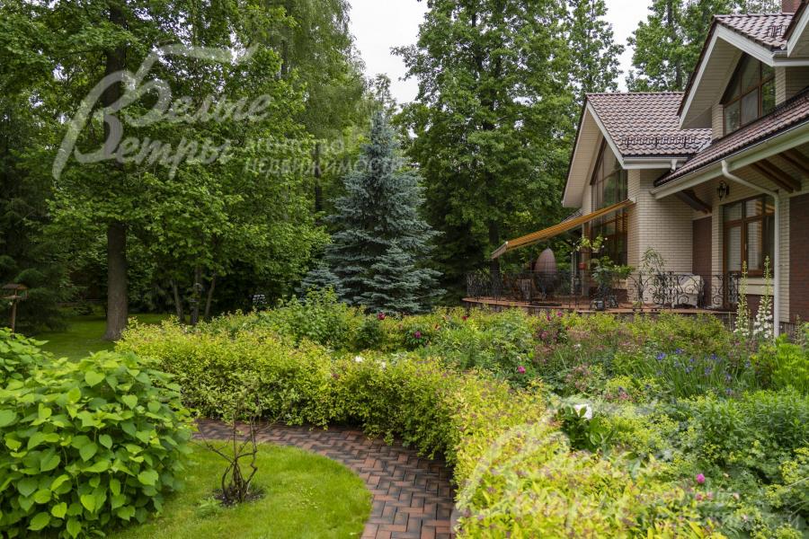 Участок украшают ухоженные декоративные кустарники и сохранённые лесные деревья