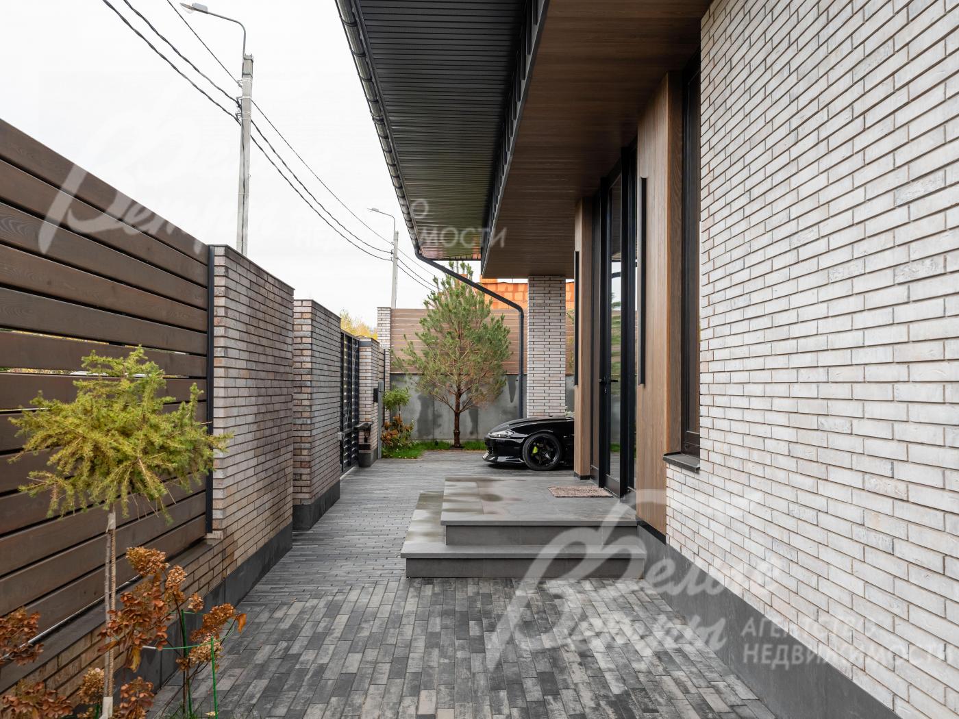 Участок огорожен по всему периметру: забор на бетонном основании и кирпичных столбах, доска - лиственница