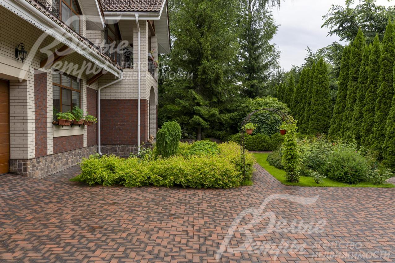 Дорожки, зона открытой парковки и подъезда к гаражу вымощены эффектной немецкой клинкерной брусчаткой