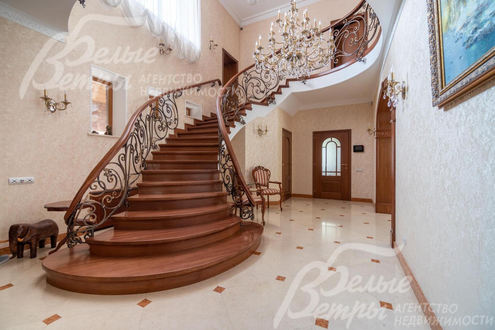 Из гостиной на второй этаж ведёт лестница, отделанная массивом дуба