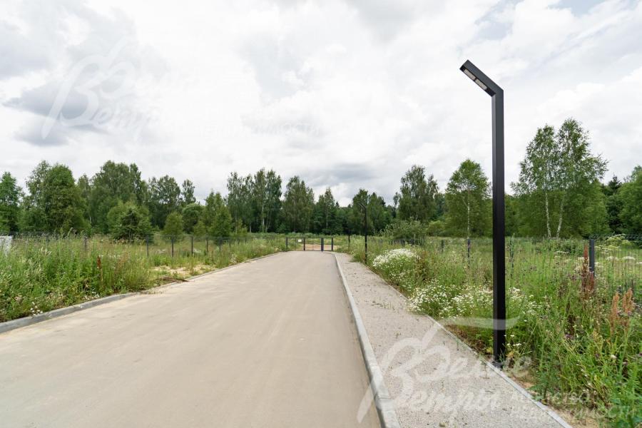 В поселке асфальтовая дорога с тротуаром, освещенная