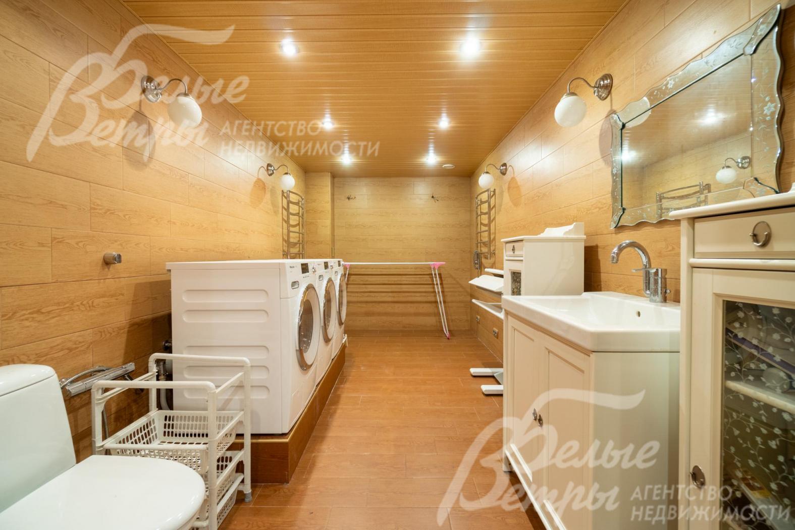 Постирочная оборудована стиральной и сушильной машинами Miele, необходимой сантехникой