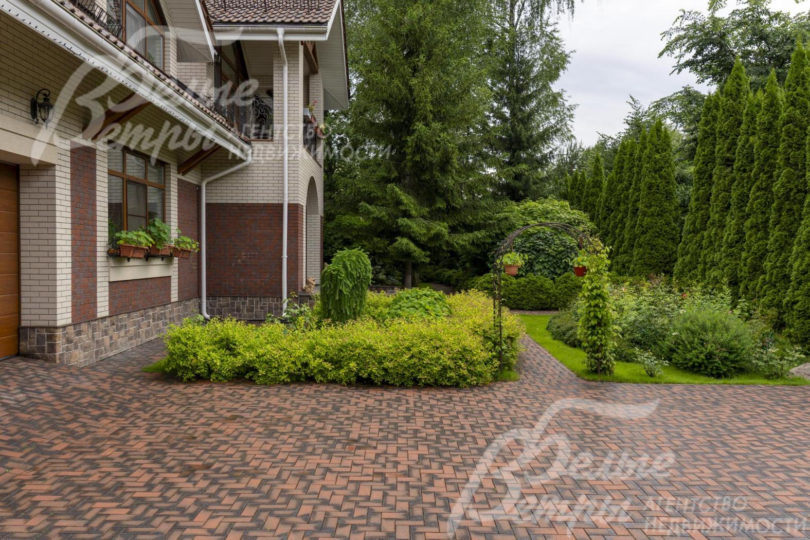 Дорожки, зона открытой парковки и подъезда к гаражу вымощены эффектной немецкой клинкерной брусчаткой