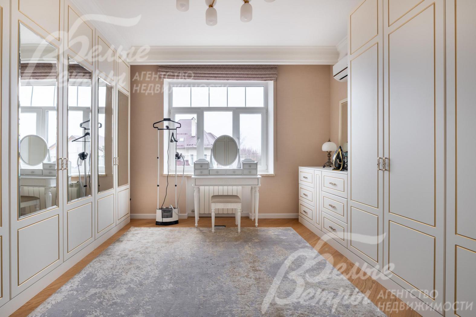 В доме на 2-м этаже - просторная гардеробная с элегантными шкафами и туалетным столиком у окна