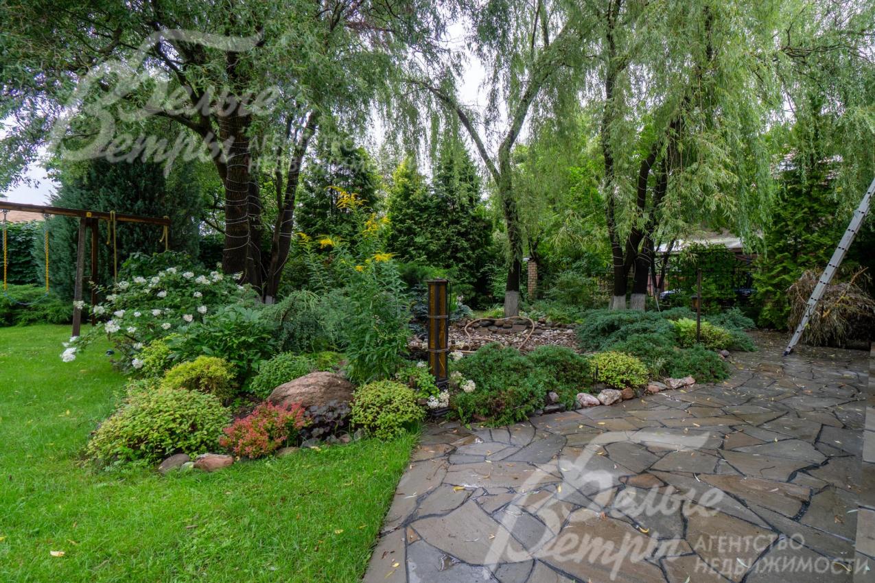 Участок украшает декоративный пруд, площадка у пруда выложена диким камнем