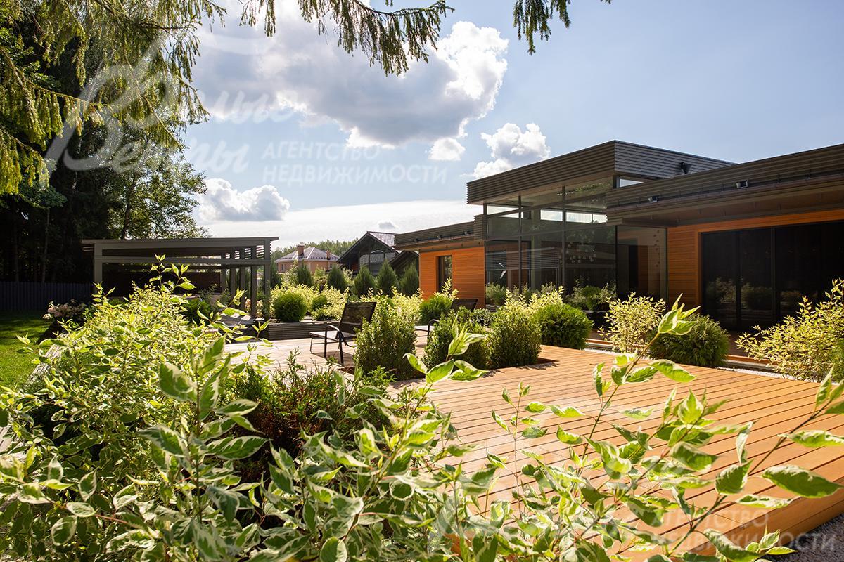 Стильная открытая терраса между домом и лесными деревьями