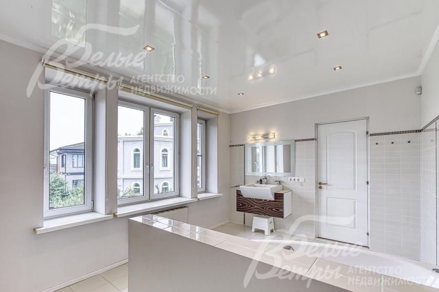 В санузле мастер-спальни - большая площадь остекления, благодаря белоснежной отделке пространство кажется ещё более просторным и воздушным