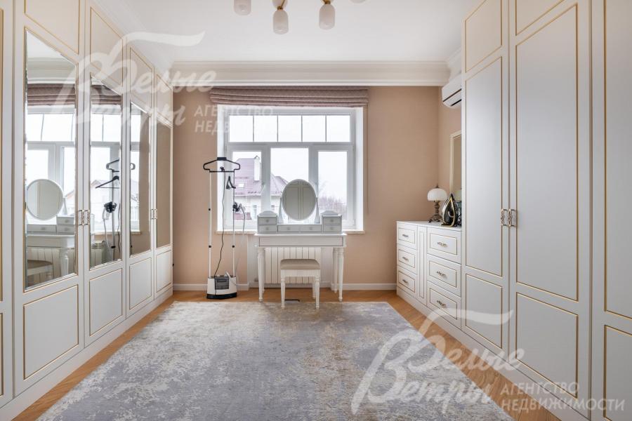 В доме на 2-м этаже - просторная гардеробная с элегантными шкафами и туалетным столиком у окна