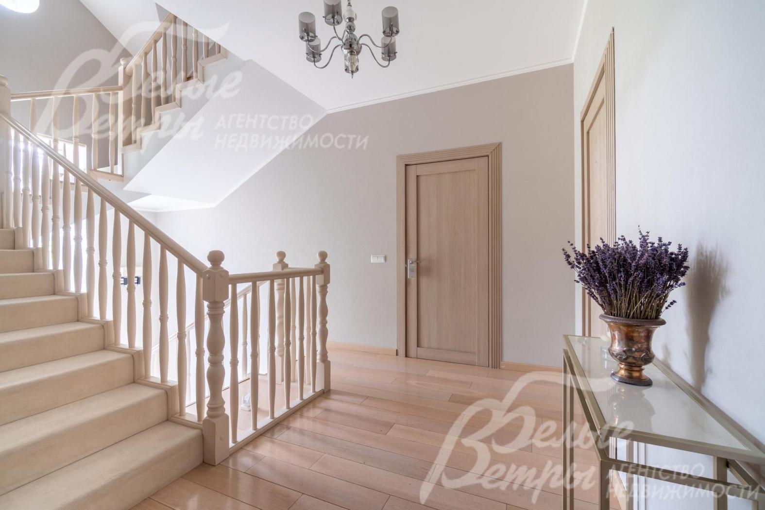 На ступенях лестницы - светлый ковролин, перила и поручни деревянные