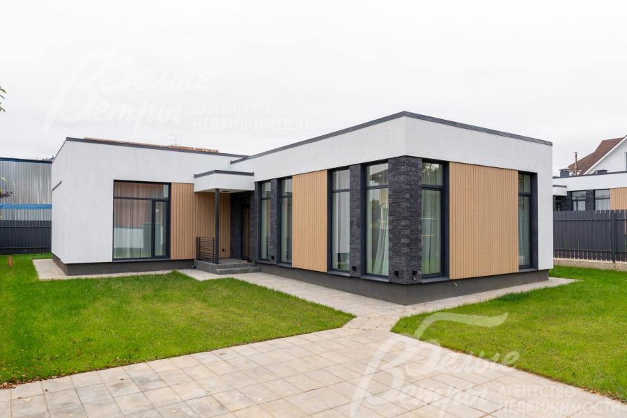 На участке - ровный газон и мощёные дорожки