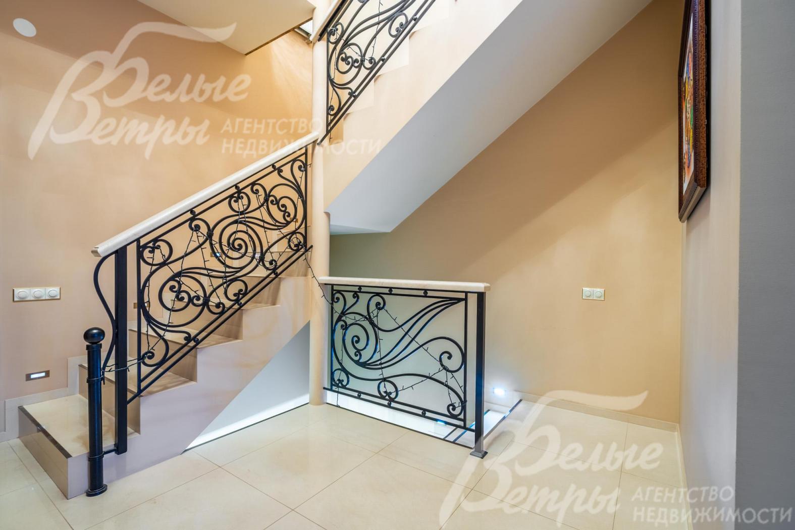 На мансардный и цокольный этажи ведёт лестница со ступенями, отделанными бежевой плиткой с окантовкой, перилами из итальянского мрамора