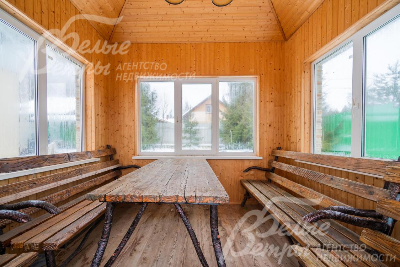 Закрытая беседка с садовой мебелью из дерева