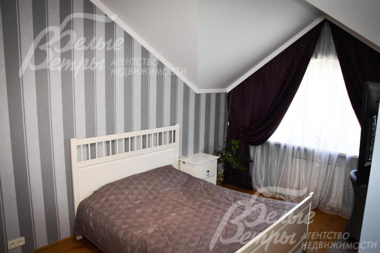 Спальня на мансардном этаже. оформленная в серо-коричневых тонах