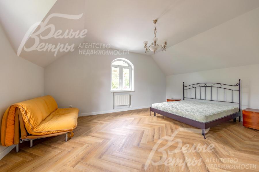 В спальне установлена кровать, прикроватные тумбы, кушетка