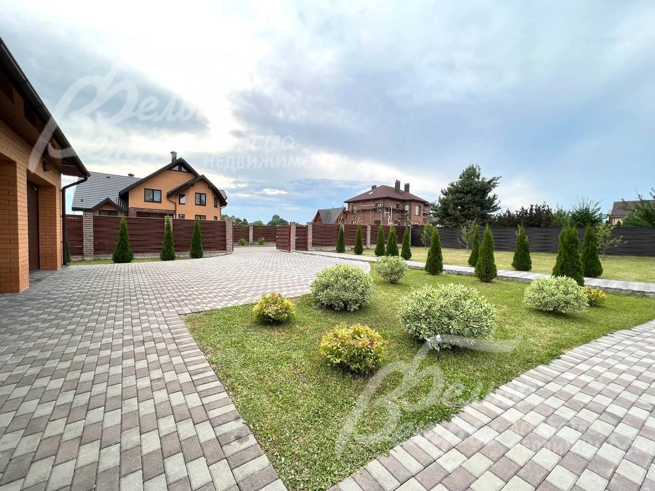 Площадка перед гаражом вымощена брусчаткой.