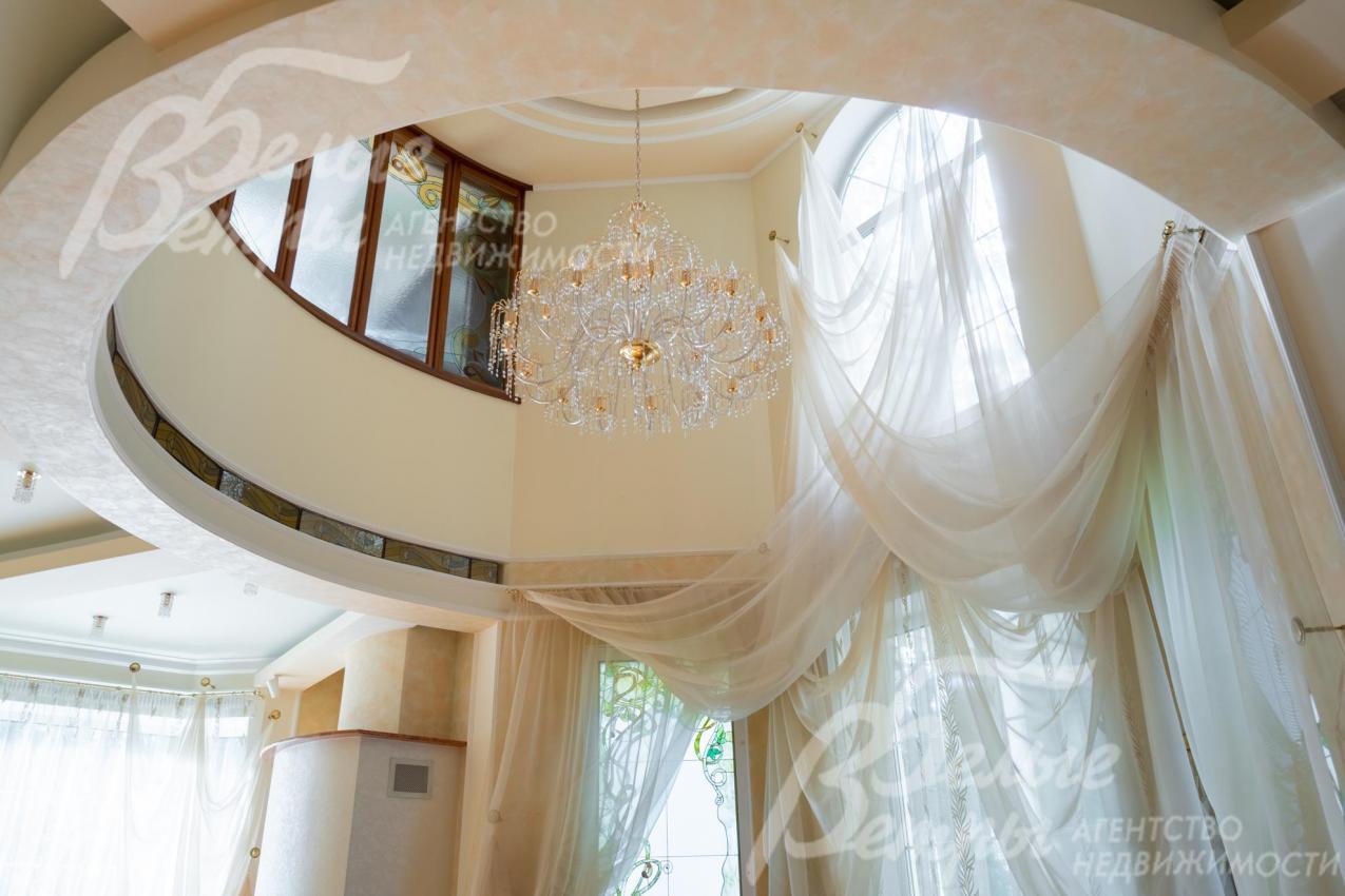 Гостиную украшают воздушные лёгкие шторы и дорогостоящая люстра