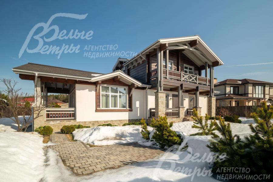 Дом стоит на ухоженном участке с ландшафтным дизайном, с двумя теплицами и хозяйственным блоком