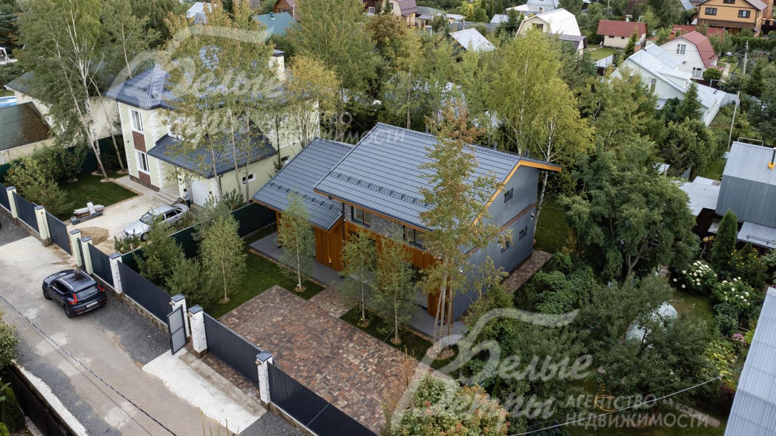 Ограждение по фасаду: металлопрофиль высотой 2,5 м на бетонном основании со столбами облицованными камнем 