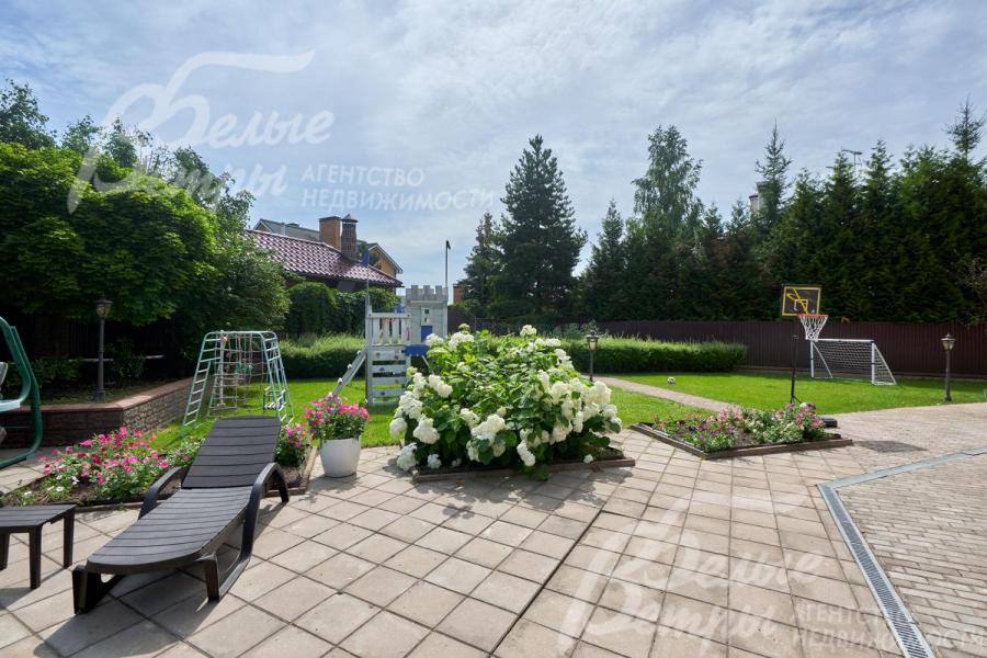 Дорожки и зоны отдыха вымощены плиткой, есть цветочные клумбы и шезлонги