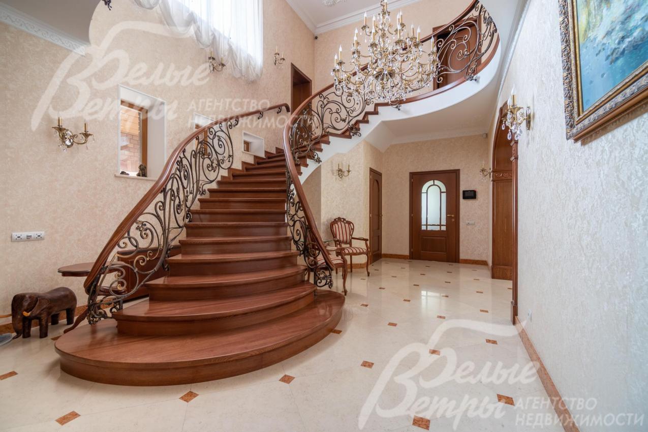 Из гостиной на второй этаж ведёт лестница, отделанная массивом дуба