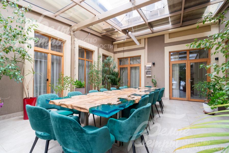 В зимнем саду расположен стол, покрытый эпоксидной смолой, рассчитанный на 16 персон