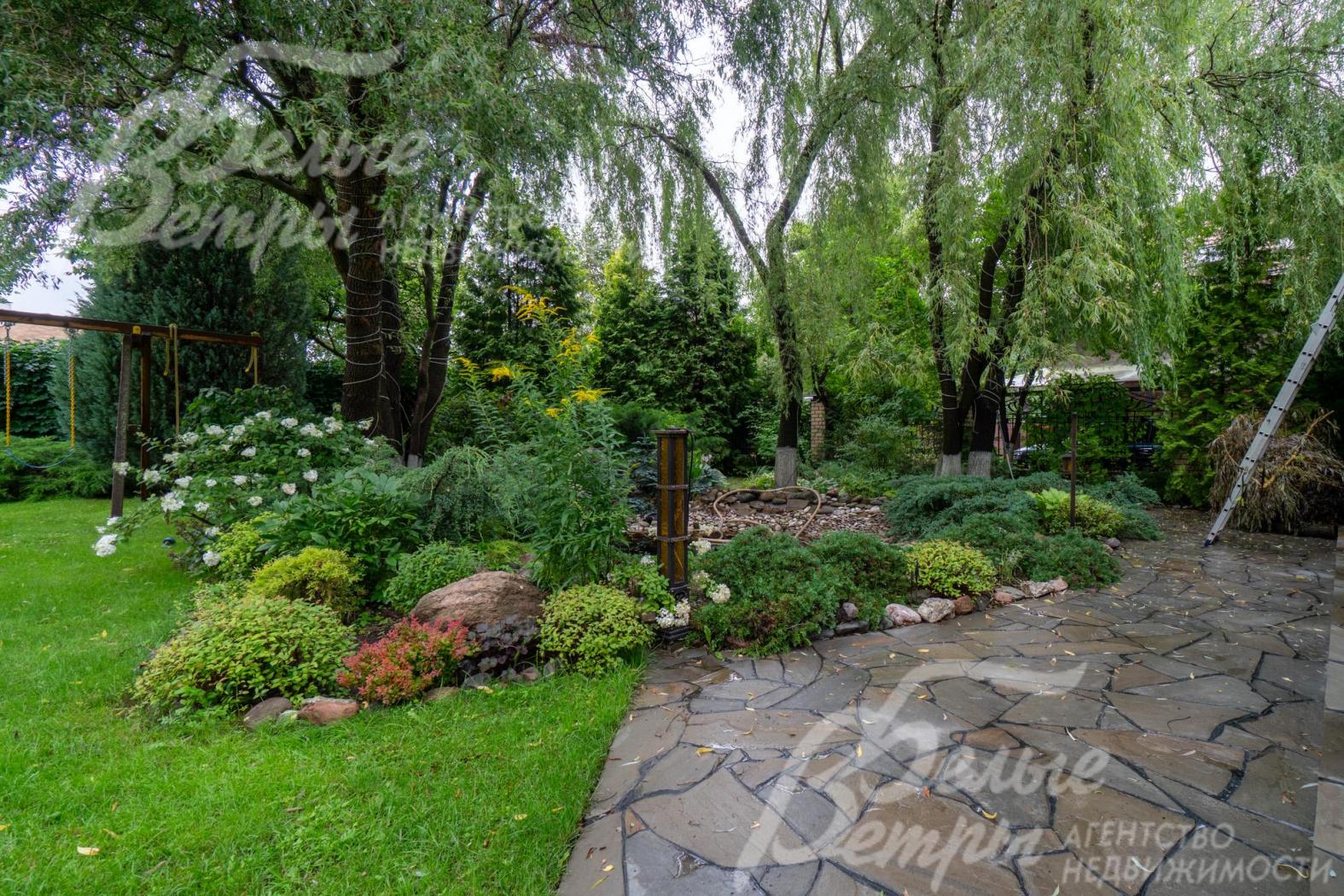 Участок украшает декоративный пруд, площадка у пруда выложена диким камнем