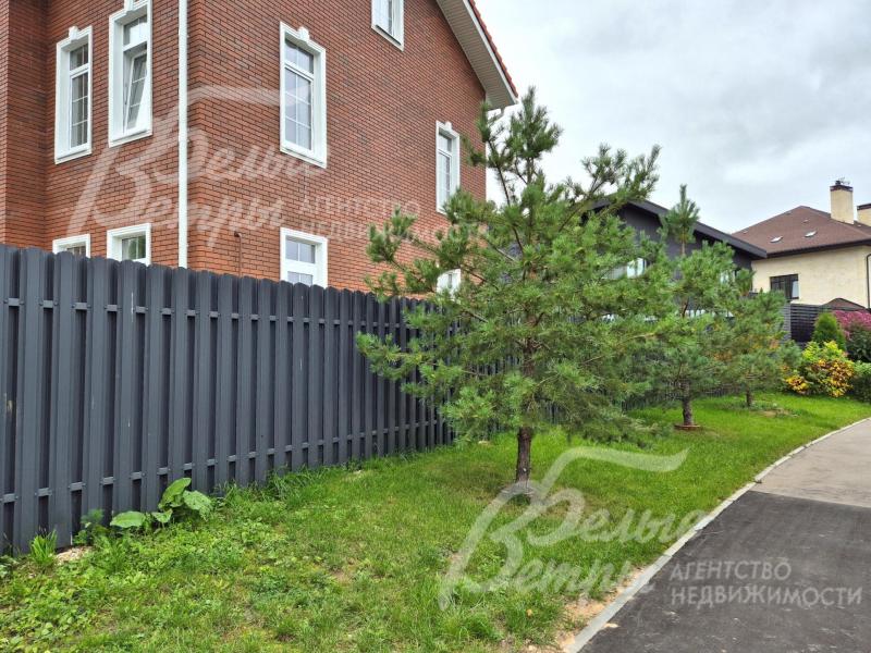 Хвойные деревья высажены вдоль участка.