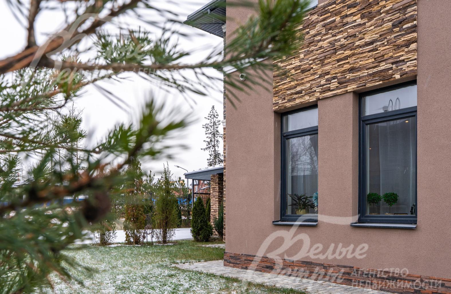 По границе участка высажены туи, сосны и декоративные кустарники