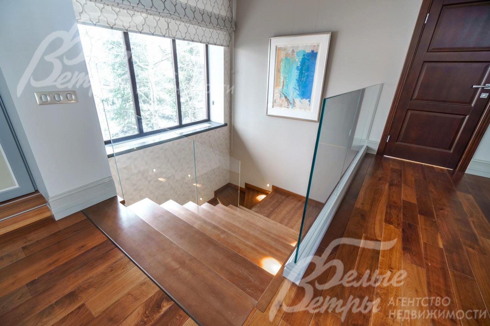 Монолитная лестница со ступенями из бука и стеклянным ограждением. Ширина этого пролета 150см.