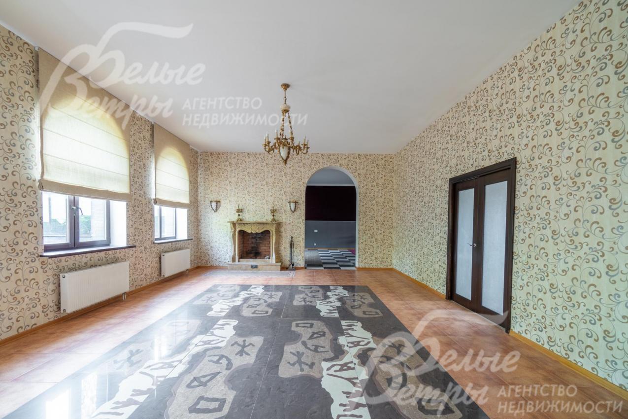 Гостиную украшают бронзовая люстра, камин, напольное панно из гранита 