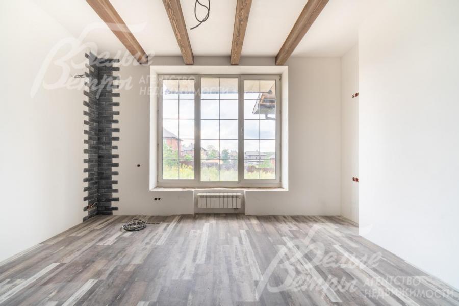 Одна из жилых комнат на втором этаже: угловая часть стены декорирована выразительной контрастной отделкой "под кирпич"