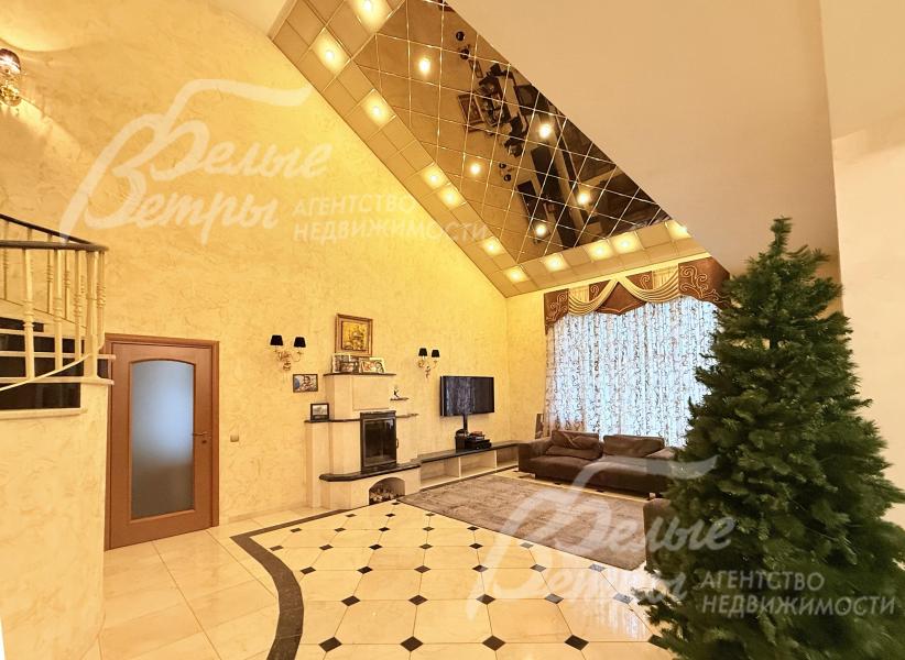 Интерьер каминного зала выполнен в элегантном стиле, включает диванную диванную группу с ковром, ТВ, зеркальный потолок второго света